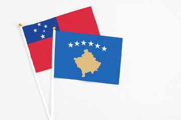 Kosovo and Samoa stick flags on white background. High quality fabric, miniature national flag. Peaceful global concept.White floor for copy space.