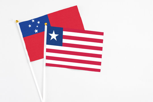 Liberia and Samoa stick flags on white background. High quality fabric, miniature national flag. Peaceful global concept.White floor for copy space.