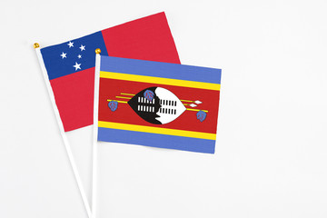 Swaziland and Samoa stick flags on white background. High quality fabric, miniature national flag. Peaceful global concept.White floor for copy space.