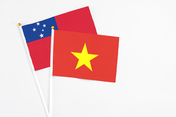 Vietnam and Samoa stick flags on white background. High quality fabric, miniature national flag. Peaceful global concept.White floor for copy space.