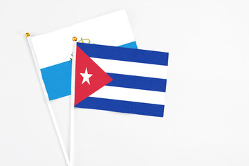 Cuba and San Marino stick flags on white background. High quality fabric, miniature national flag. Peaceful global concept.White floor for copy space.