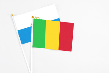 Mali and San Marino stick flags on white background. High quality fabric, miniature national flag. Peaceful global concept.White floor for copy space.