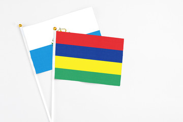 Mauritius and San Marino stick flags on white background. High quality fabric, miniature national flag. Peaceful global concept.White floor for copy space.