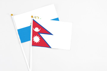 Nepal and San Marino stick flags on white background. High quality fabric, miniature national flag. Peaceful global concept.White floor for copy space.