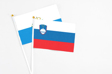Slovenia and San Marino stick flags on white background. High quality fabric, miniature national flag. Peaceful global concept.White floor for copy space.