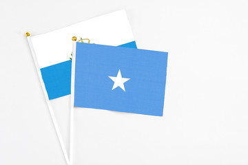 Somalia and San Marino stick flags on white background. High quality fabric, miniature national flag. Peaceful global concept.White floor for copy space.