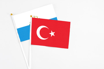 Turkey and San Marino stick flags on white background. High quality fabric, miniature national flag. Peaceful global concept.White floor for copy space.