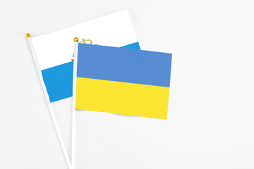 Ukraine and San Marino stick flags on white background. High quality fabric, miniature national flag. Peaceful global concept.White floor for copy space.