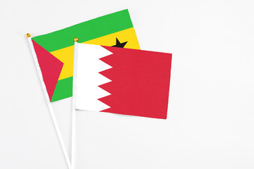 Bahrain and Sao Tome And Principe stick flags on white background. High quality fabric, miniature national flag. Peaceful global concept.White floor for copy space.