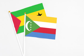 Comoros and Sao Tome And Principe stick flags on white background. High quality fabric, miniature national flag. Peaceful global concept.White floor for copy space.