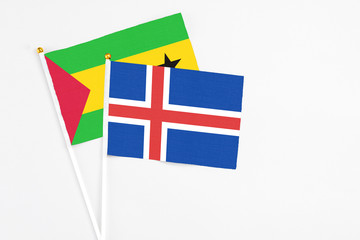 Obraz premium Iceland and Sao Tome And Principe stick flags on white background. High quality fabric, miniature national flag. Peaceful global concept.White floor for copy space.