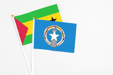 Northern Mariana Islands and Sao Tome And Principe stick flags on white background. High quality fabric, miniature national flag. Peaceful global concept.White floor for copy space.