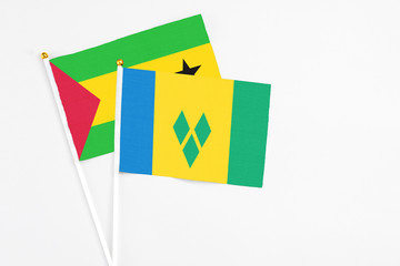 Saint Vincent And The Grenadines and Sao Tome And Principe stick flags on white background. High quality fabric, miniature national flag. Peaceful global concept.White floor for copy space.