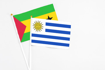 Uruguay and Sao Tome And Principe stick flags on white background. High quality fabric, miniature national flag. Peaceful global concept.White floor for copy space.