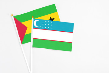 Uzbekistan and Sao Tome And Principe stick flags on white background. High quality fabric, miniature national flag. Peaceful global concept.White floor for copy space.