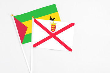 Jersey and Saudi Arabia stick flags on white background. High quality fabric, miniature national flag. Peaceful global concept.White floor for copy space.