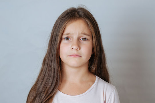 Emotional portrait of strong emotions tears of a little beautiful girl on a white background