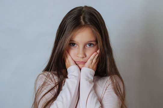 Emotional portrait of strong emotions tears of a little beautiful girl on a white background