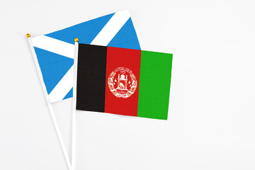 Afghanistan and Scotland stick flags on white background. High quality fabric, miniature national flag. Peaceful global concept.White floor for copy space.