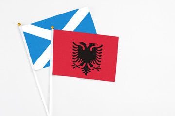 Obraz premium Albania and Scotland stick flags on white background. High quality fabric, miniature national flag. Peaceful global concept.White floor for copy space.