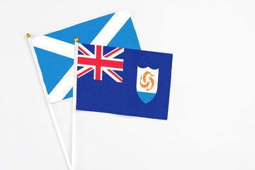 Anguilla and Scotland stick flags on white background. High quality fabric, miniature national flag. Peaceful global concept.White floor for copy space.