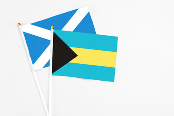 Bahamas and Scotland stick flags on white background. High quality fabric, miniature national flag. Peaceful global concept.White floor for copy space.