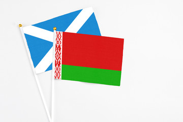 Belarus and Scotland stick flags on white background. High quality fabric, miniature national flag. Peaceful global concept.White floor for copy space.