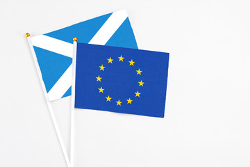 European Union and Scotland stick flags on white background. High quality fabric, miniature national flag. Peaceful global concept.White floor for copy space.