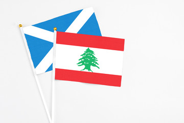Lebanon and Scotland stick flags on white background. High quality fabric, miniature national flag. Peaceful global concept.White floor for copy space.