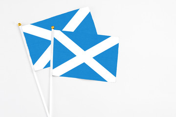 Scotland and Scotland stick flags on white background. High quality fabric, miniature national flag. Peaceful global concept.White floor for copy space.