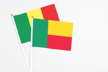 Benin and Senegal stick flags on white background. High quality fabric, miniature national flag. Peaceful global concept.White floor for copy space.