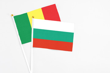 Bulgaria and Senegal stick flags on white background. High quality fabric, miniature national flag. Peaceful global concept.White floor for copy space.