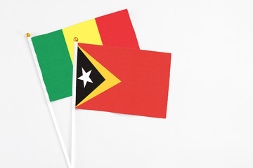 East Timor and Senegal stick flags on white background. High quality fabric, miniature national flag. Peaceful global concept.White floor for copy space.