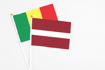 Latvia and Senegal stick flags on white background. High quality fabric, miniature national flag. Peaceful global concept.White floor for copy space.