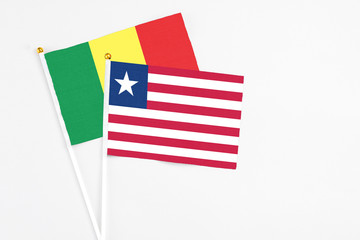 Liberia and Senegal stick flags on white background. High quality fabric, miniature national flag. Peaceful global concept.White floor for copy space.