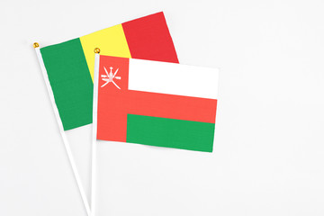Oman and Senegal stick flags on white background. High quality fabric, miniature national flag. Peaceful global concept.White floor for copy space.