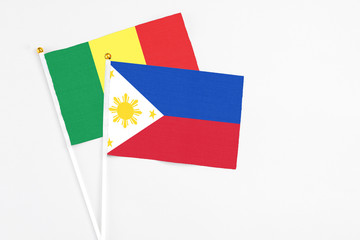 Philippines and Senegal stick flags on white background. High quality fabric, miniature national flag. Peaceful global concept.White floor for copy space.
