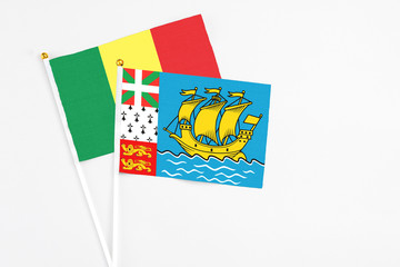 Saint Pierre And Miquelon and Senegal stick flags on white background. High quality fabric, miniature national flag. Peaceful global concept.White floor for copy space.