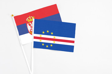 Cape Verde and Serbia stick flags on white background. High quality fabric, miniature national flag. Peaceful global concept.White floor for copy space.