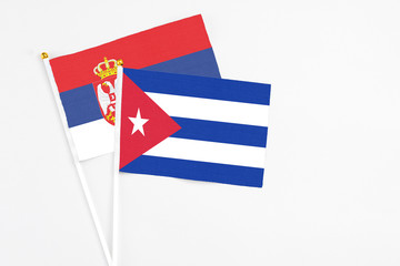 Cuba and Serbia stick flags on white background. High quality fabric, miniature national flag....