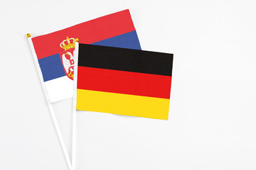 Germany and Serbia stick flags on white background. High quality fabric, miniature national flag. Peaceful global concept.White floor for copy space.