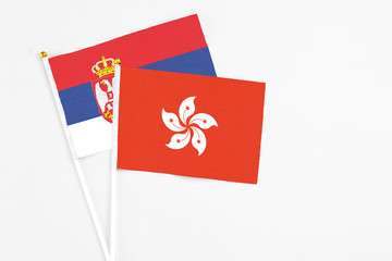 Hong Kong and Serbia stick flags on white background. High quality fabric, miniature national flag. Peaceful global concept.White floor for copy space.