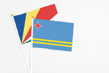 Aruba and Seychelles stick flags on white background. High quality fabric, miniature national flag. Peaceful global concept.White floor for copy space.v