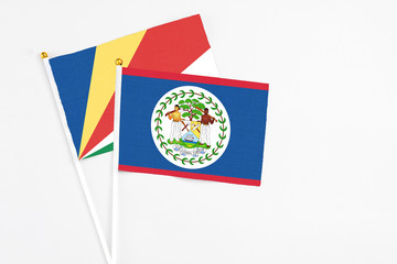 Belize and Seychelles stick flags on white background. High quality fabric, miniature national flag. Peaceful global concept.White floor for copy space.v