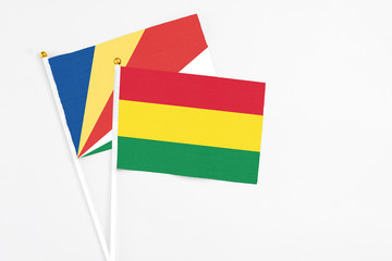 Bolivia and Seychelles stick flags on white background. High quality fabric, miniature national flag. Peaceful global concept.White floor for copy space.v