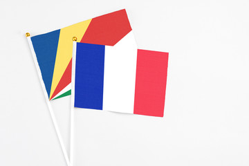 France and Seychelles stick flags on white background. High quality fabric, miniature national flag. Peaceful global concept.White floor for copy space.v