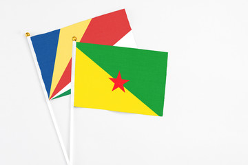 French Guiana and Seychelles stick flags on white background. High quality fabric, miniature national flag. Peaceful global concept.White floor for copy space.v