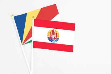 French Polynesia and Seychelles stick flags on white background. High quality fabric, miniature national flag. Peaceful global concept.White floor for copy space.v