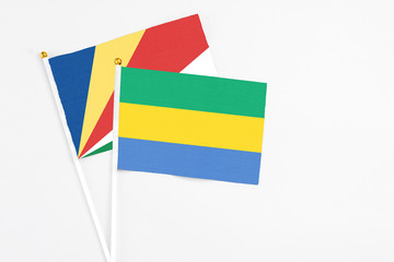 Gabon and Seychelles stick flags on white background. High quality fabric, miniature national flag....