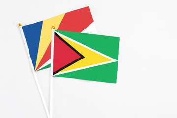 Guyana and Seychelles stick flags on white background. High quality fabric, miniature national flag. Peaceful global concept.White floor for copy space.v